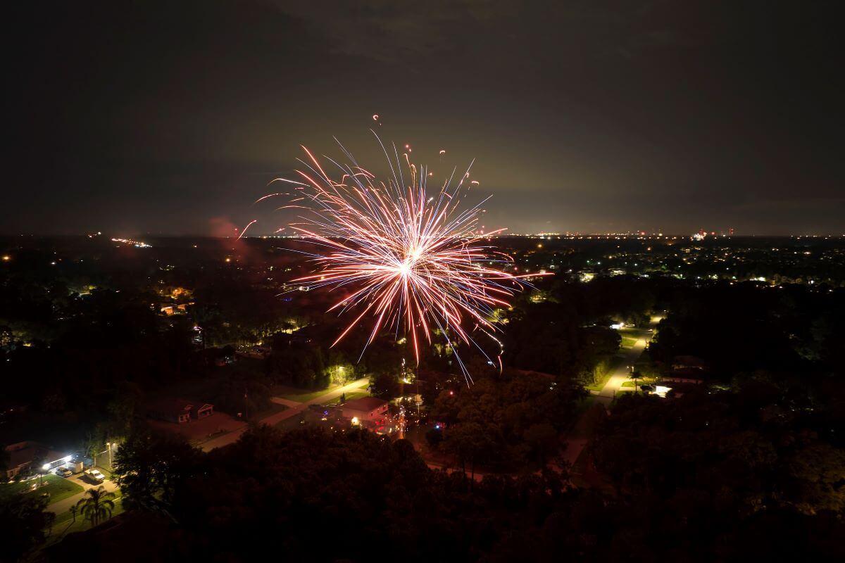 Fireworks illuminating the night sky above a neighborhood of homes, symbolizing home safety during Independence Day celebrations