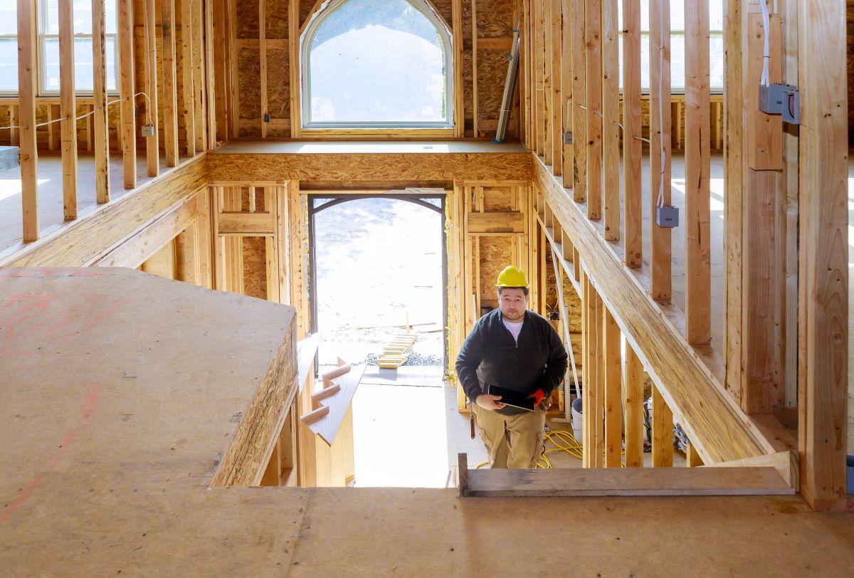 home inspector walking up the stairs of a new home under construction in DFW